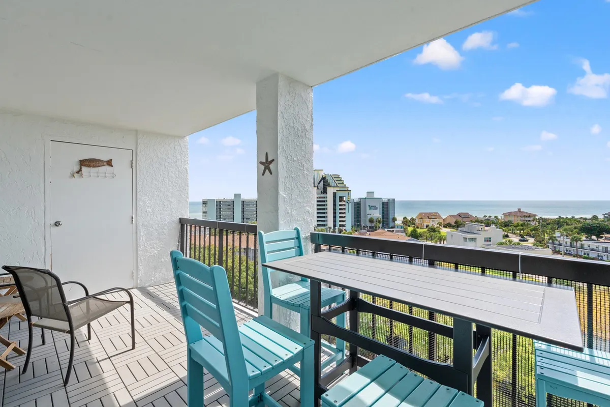 A tranquil ocean-view balcony featuring outdoor furniture and sturdy railings. The seating area invites gatherings for coffee at dawn or sunset chats, offering a stunning panorama of the sea—ideal for multi-generational relaxation or family bonding moments.